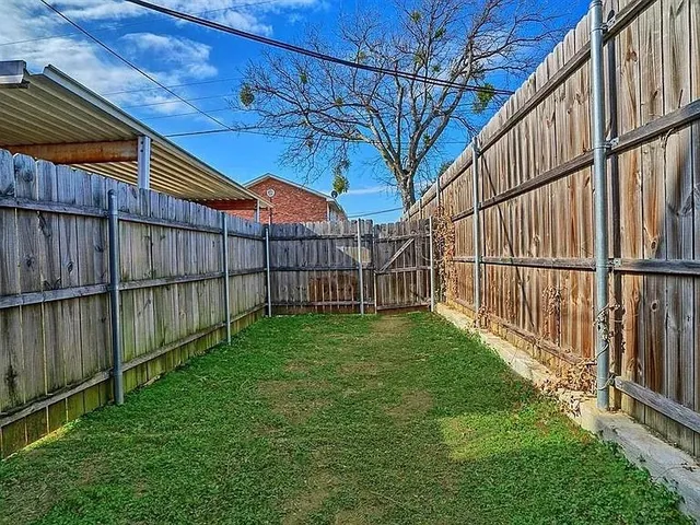 a view of yard with wooden fence and trees