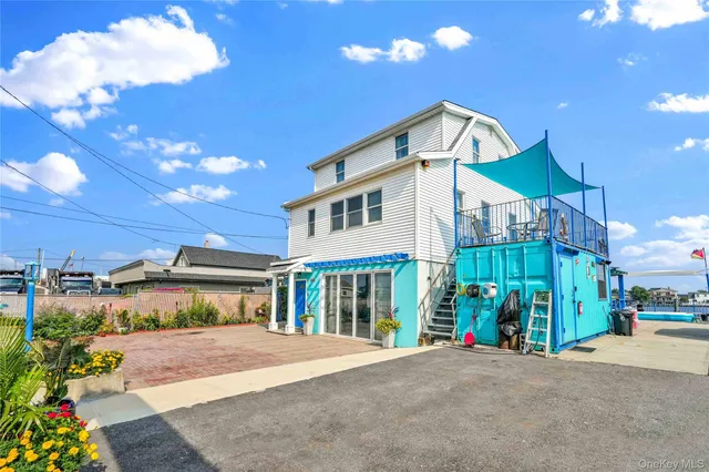 a kitchen with stainless steel appliances kitchen island granite countertop a stove top oven a sink a dining table and chairs with wooden floor