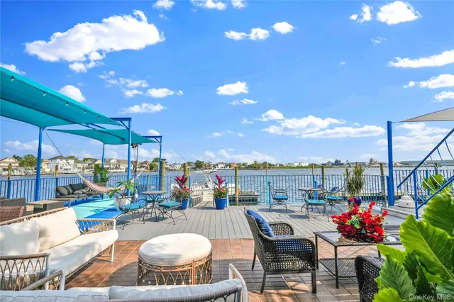 a living room with stainless steel appliances kitchen island granite countertop furniture a rug a kitchen island a chandelier and a view of kitchen