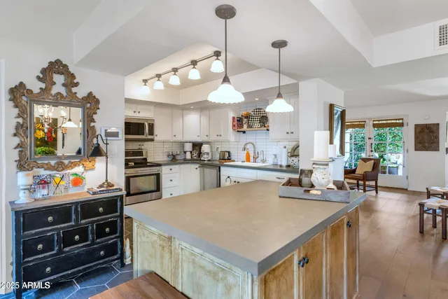 a kitchen with a stove a refrigerator and a flat screen tv