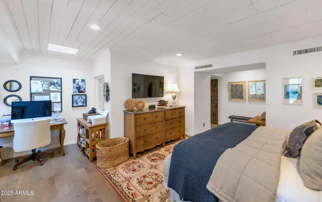 a bedroom with furniture and a flat screen tv
