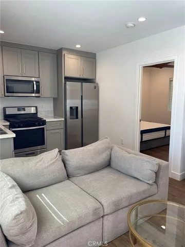 a living room with a couch and a stainless steel appliances