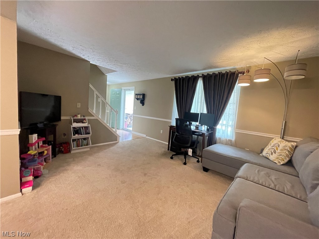 9572 Hoose Road Mentor, OH 44060 - Photo 13 of 35 Carpeted living room, stairs to upstairs and front door.