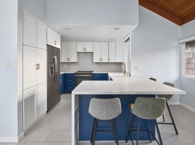 a kitchen with stainless steel appliances granite countertop a sink a refrigerator and a stove