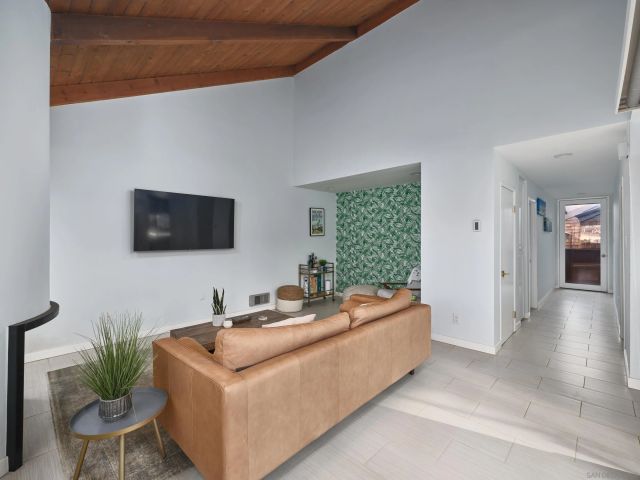 a living room with stainless steel appliances kitchen island furniture and a flat screen tv