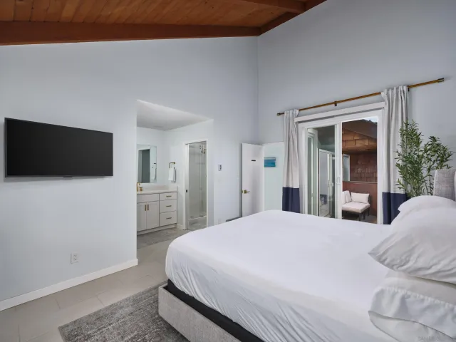 a bedroom with a bed and a flat screen tv