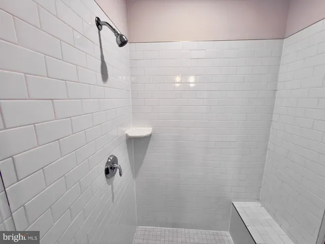 a bathroom with a tub sink mirror and a shower