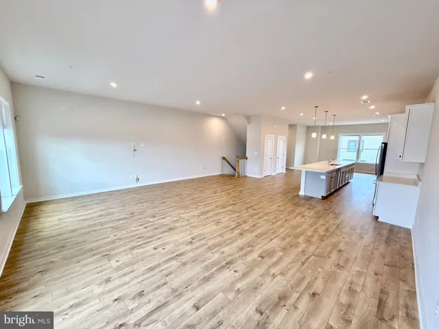 a view of a kitchen with kitchen island white cabinets and wooden floor