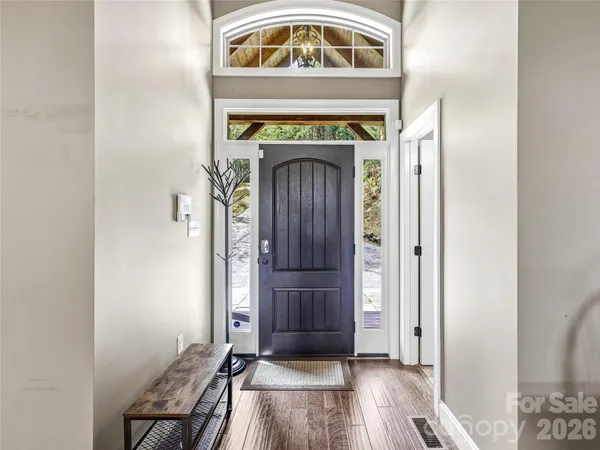 a dining room with furniture a chandelier and wooden floor