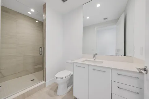 a bathroom with a sink a toilet and shower