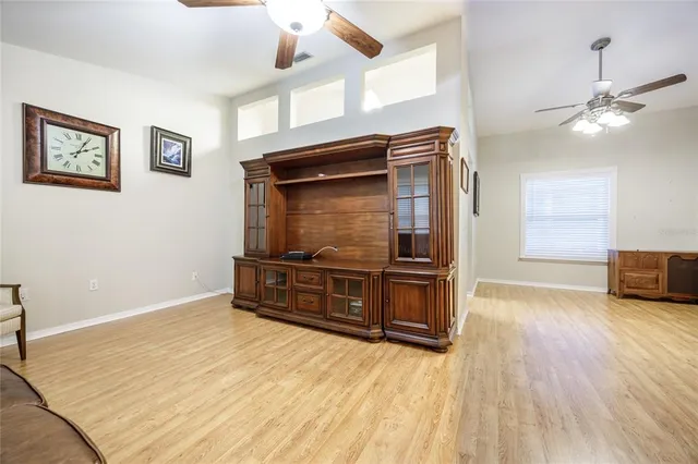 a room with wooden floor and ceiling fan