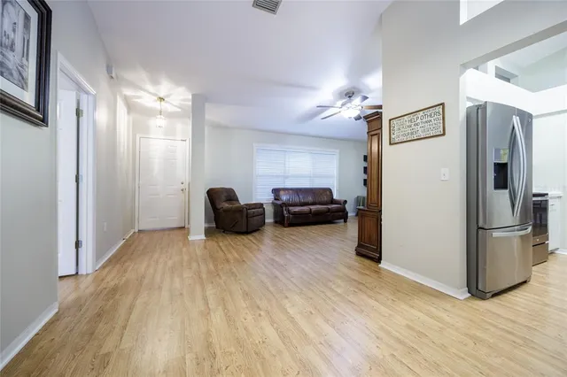 a living room with furniture and a refrigerator