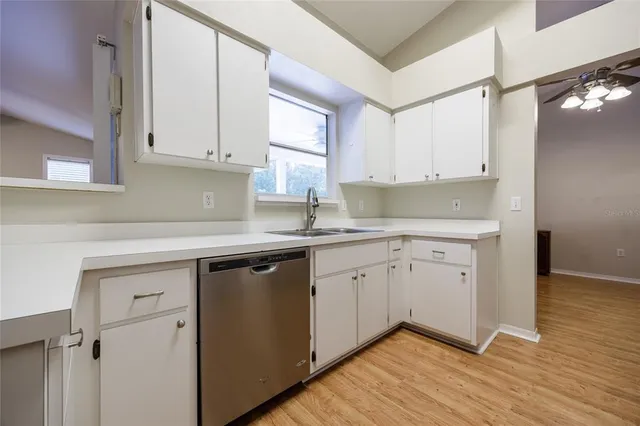 a kitchen with granite countertop white cabinets and white appliances