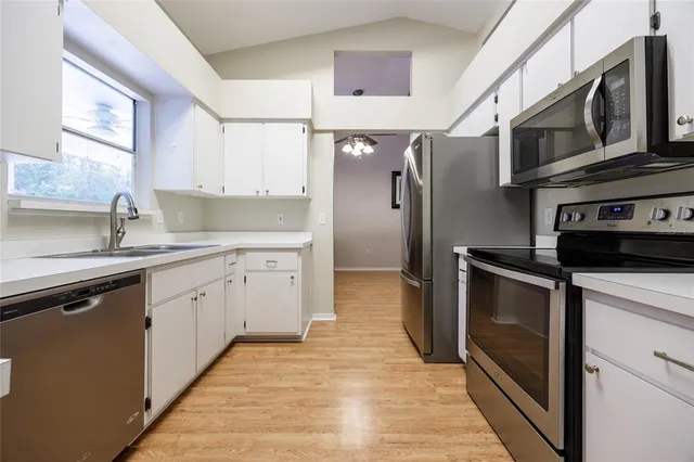 a kitchen with stainless steel appliances granite countertop a refrigerator and a sink