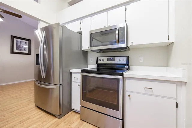 a kitchen with stainless steel appliances granite countertop a refrigerator microwave and sink