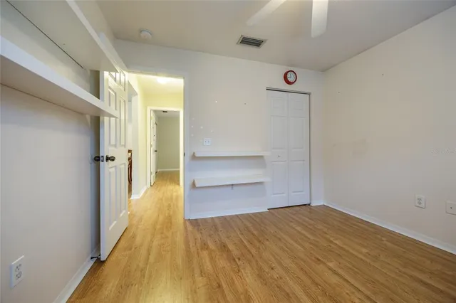 a view of a room with wooden floor and a ceiling fan