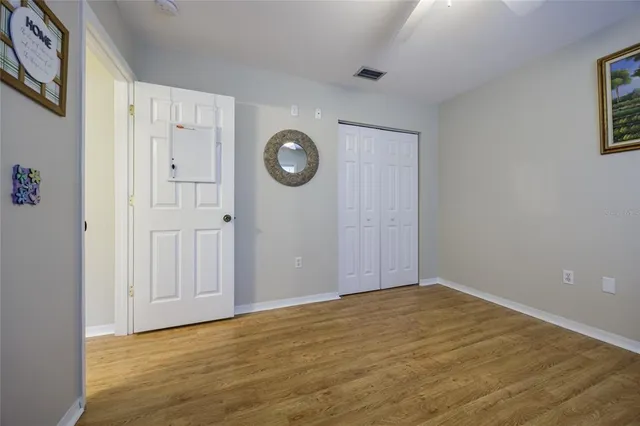 a view of an empty room with wooden floor