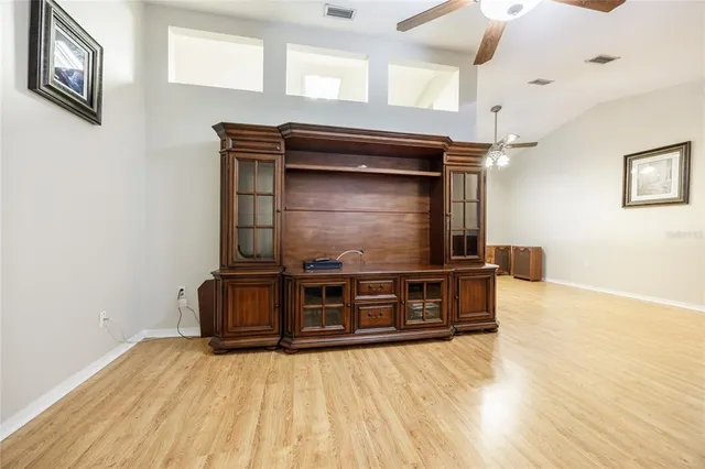 a living room with stainless steel appliances wooden floor and a window