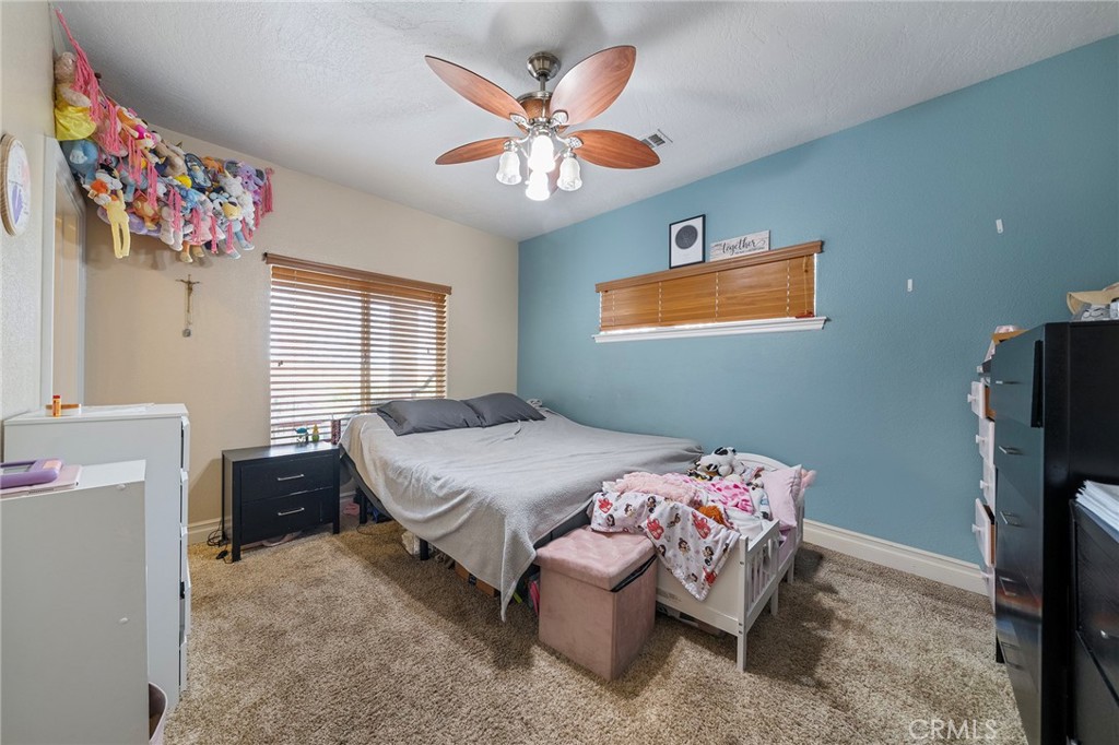 7172 Jargon Road Hesperia, CA 92344 - Photo 23 of 75 a bedroom with a bed and a chandelier