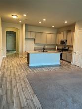 1913 Ridge Creek Lane Aubrey, TX 76227 - Photo 2 of 21 a view of kitchen with kitchen island wooden floor center island and stainless steel appliances