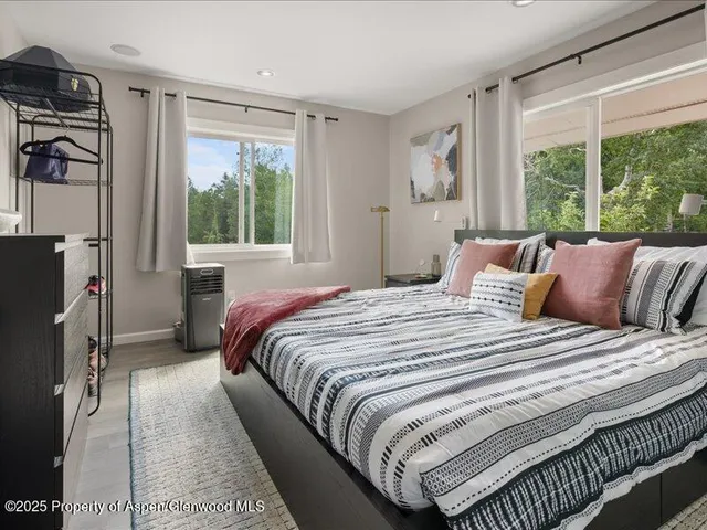 a bedroom with bed and a large window