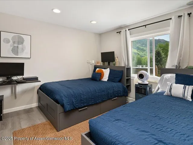 a bedroom with furniture and a large window