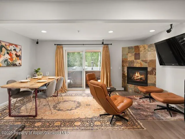 a living room with furniture a flat screen tv and a fireplace