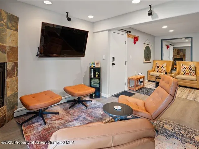 a living room with furniture a flat screen tv and kitchen view