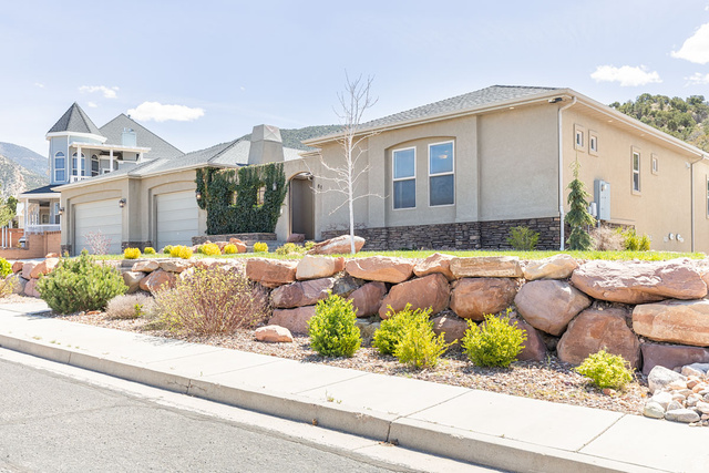 888 East Fiddlers Canyon Road Cedar City, UT 84721 - Photo 2 of 74 View of front of home with stucco siding, an attached garage, stone siding, and a chimney