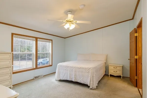 a spacious bedroom with a bed and a window