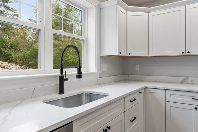a kitchen with a sink a window and stainless steel appliances