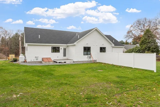 a view of a white house with a big yard and a large tree