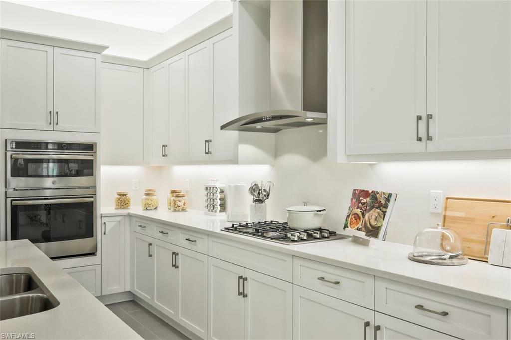 11805 Drake Lane Naples, FL 34120 - Photo 10 of 30 a kitchen with granite countertop white cabinets and white appliances