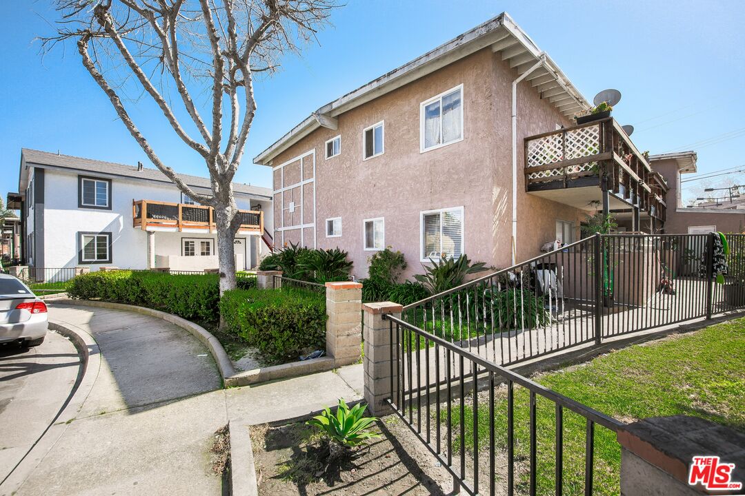 a view of a white house with iron fence and windows