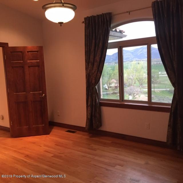 1453 Fir Court Rifle, CO 81650 - Photo 15 of 28 an empty room with wooden floor and windows