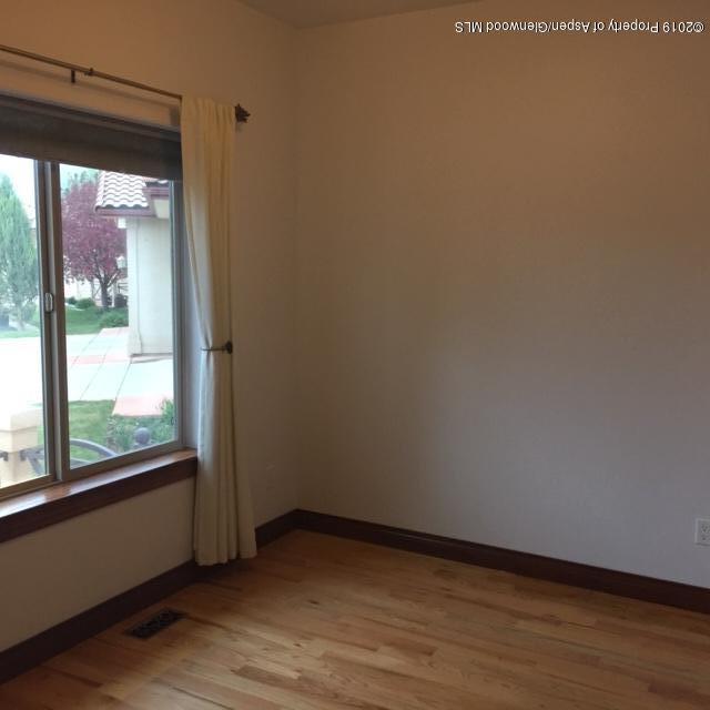 1453 Fir Court Rifle, CO 81650 - Photo 3 of 28 a view of an empty room with wooden floor and a window