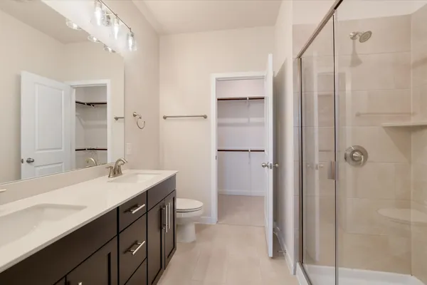 a bathroom with a double vanity sink a mirror and a shower