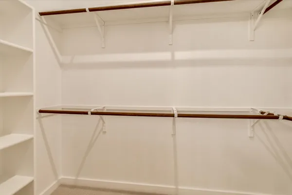 a view of walk in closet with empty racks