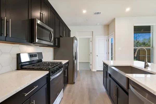 a kitchen with stainless steel appliances granite countertop a sink stove and refrigerator