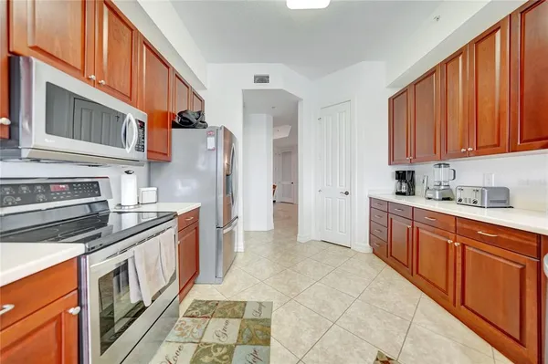 a kitchen with stainless steel appliances kitchen island granite countertop a refrigerator and a stove top oven