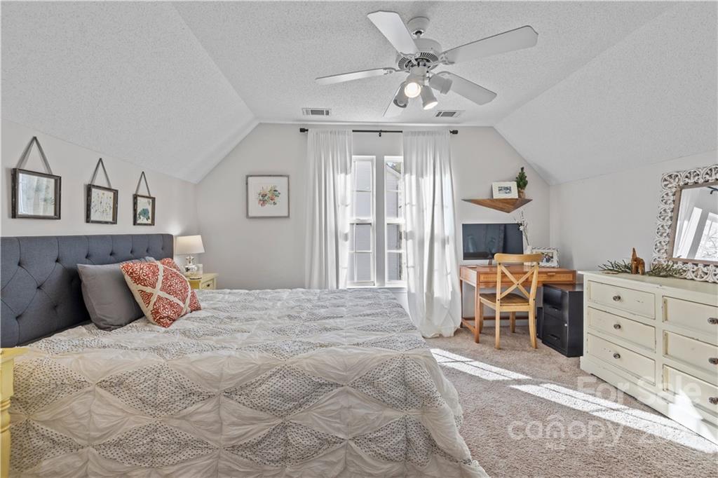 4010 Suttle Place Matthews, NC 28104 - Photo 23 of 31 a bedroom with a large bed and a chandelier