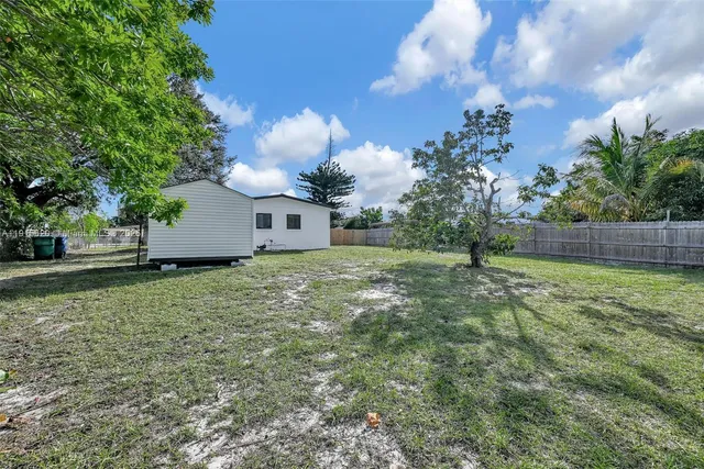 a view of a house with a yard and tree