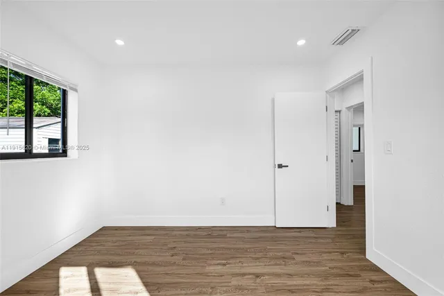 a view of a hallway with wooden floor and closet