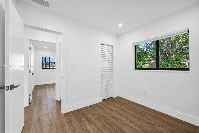 a view of an empty room with wooden floor
