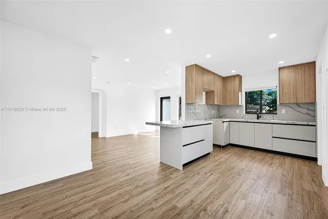 a kitchen with a sink cabinets and wooden floor