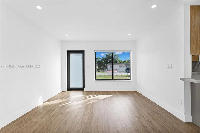 a view of an empty room with wooden floor