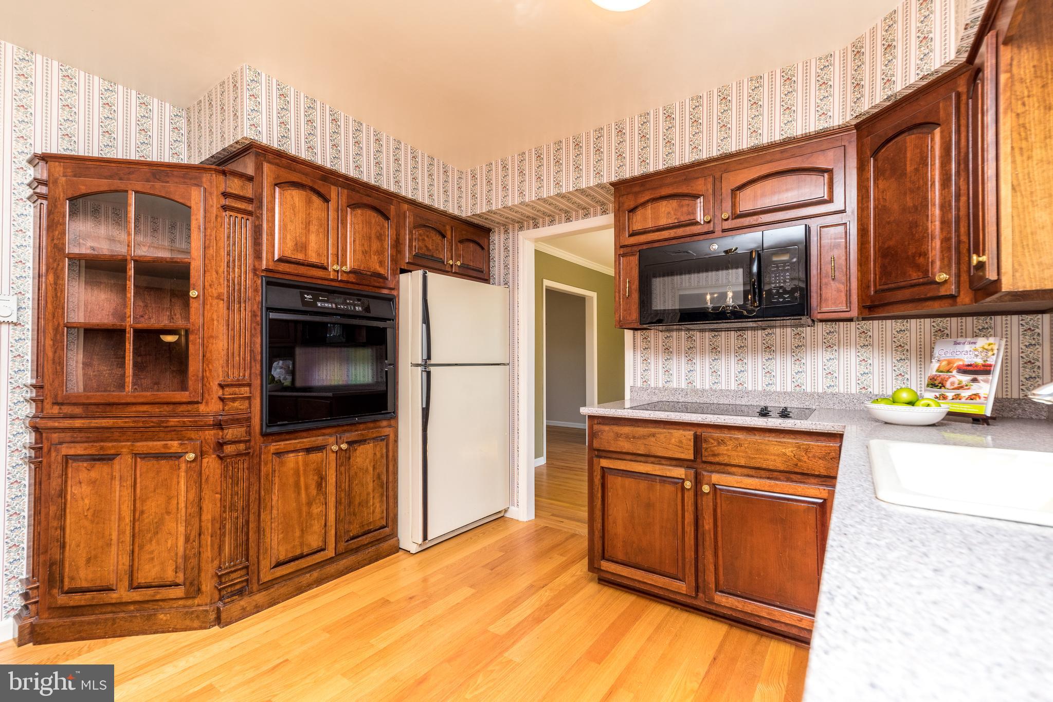 231 Parry Road Warminster, PA 18974 - Photo 21 of 71 a kitchen view with stainless steel appliances granite countertop a stove top oven a refrigerator with wooden cabinets