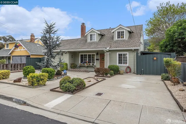 a front view of a house with a yard and potted plants