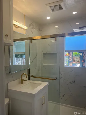 a bathroom with a sink a toilet and shower