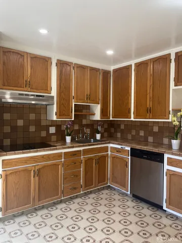 a kitchen with stainless steel appliances granite countertop a sink and cabinets